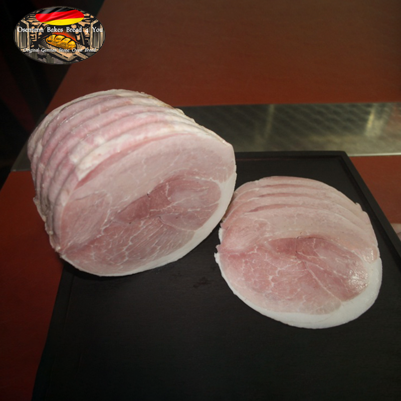 Sliced cooked ham arranged on a surface, with visible pink color and layered slices.