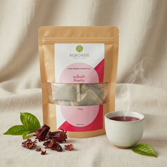 A kraft paper stand-up pouch of AGROASIE Rosella Tangy herbal tea sachets, showing the tea inside through a clear window on a white background.